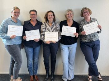 Collega's nemen TMA Expert-certificaat in ontvangst