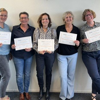Collega's nemen TMA Expert-certificaat in ontvangst